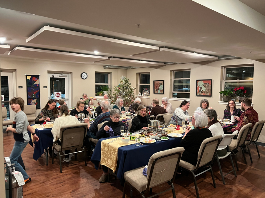 Residents celebrate New Year’s Eve 2022 with a special fondue dinner in the common dining room at Aria Cohousing in Denver, Colorado.